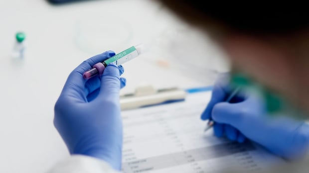  Scientist looking at COVID-19 vial 